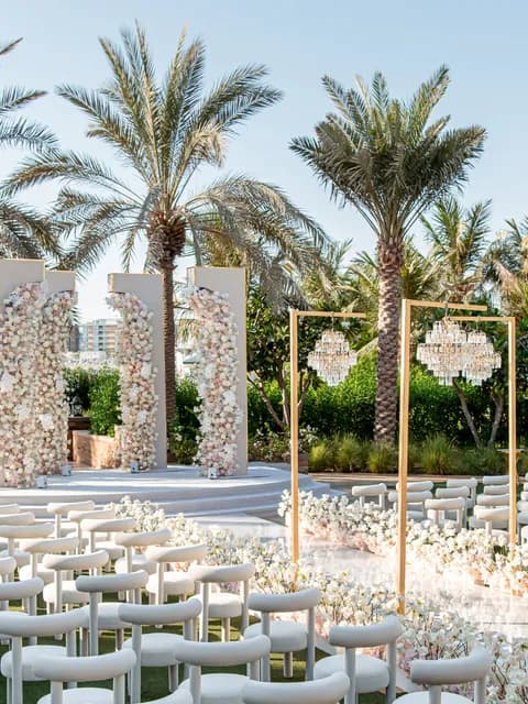 A palm-lined resort ceremony set with chandeliers in Dubai