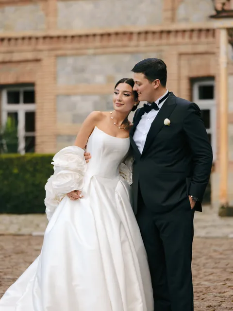 A couple photographed outside a château on their wedding day