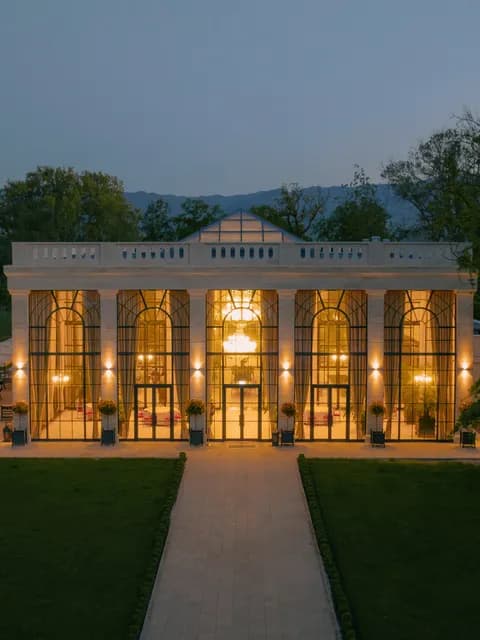 A grand estate wedding venue lit at dusk